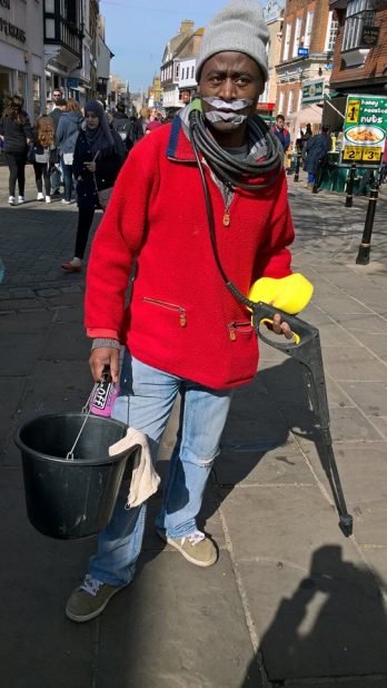 a-volunteer-dressed-as-a-car-washer-holding-a-hose-and-bucket